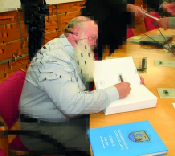 Autor Walter Scheidle beim Signieren seiner Ortssippenbücher