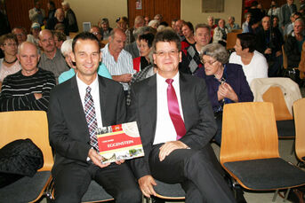 Ralf Mannherz (rechts) und Daniel Rein der Spar- und Kreditbank Hardt im gut besuchten Kronesaal. Sie haben die Chronik mit 10.000 € gefördert.